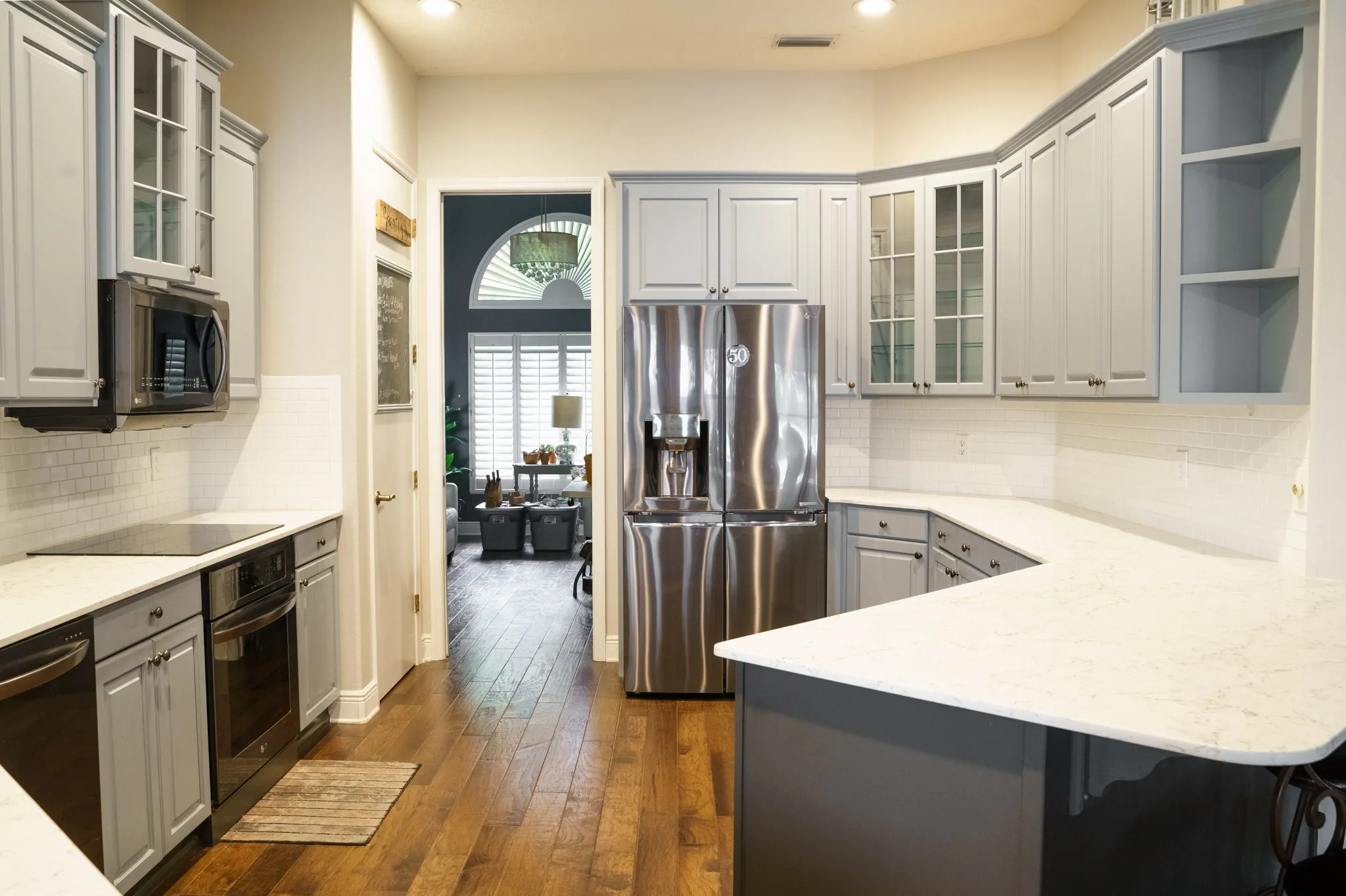 St. Petersburg kitchen before refacing, with grey arched raised-panel cabinet doors, glass-front uppers and a navy peninsula